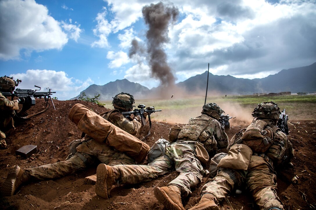 Soldiers provide suppressive fire after breaching an obstacle.