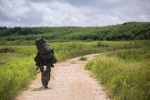 Cpl. Daniel Mehaffey carries his gear to the rendezvous point after parachuting 10,000 feet during parachute training operations Aug. 13, 2018 at Ie Shima, Okinawa, Japan. Landing Support Company completed parachute and air delivery training to ensure Marines maintain proficiency and meet required training hours. Mehaffey, a parachute rigger with Air Delivery Platoon, LS Co., 3rd Transportation Support Battalion, is a native of Warminster, Pennsylvania. (U.S. Marine Corps photo by Lance Cpl. Jamin M. Powell)