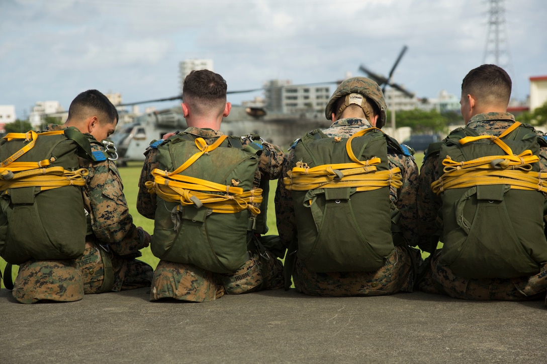 Marines with Landing Support Company, 3rd Transportation Support Battalion, 3rd Marine Logistics Group, wait next to the Camp Foster parade deck to board a CH-53E Super Stallion helicopter during parachute and air delivery training operations Aug. 14, 2018 at Ie Shima, Okinawa, Japan. The training consisted of low-level static line and military free fall jumps at 10,000 feet in order to keep the Marines proficient as parachute rigger and air delivery specialists. (U.S. Marine Corps photo by Cpl. Isabella Ortega)