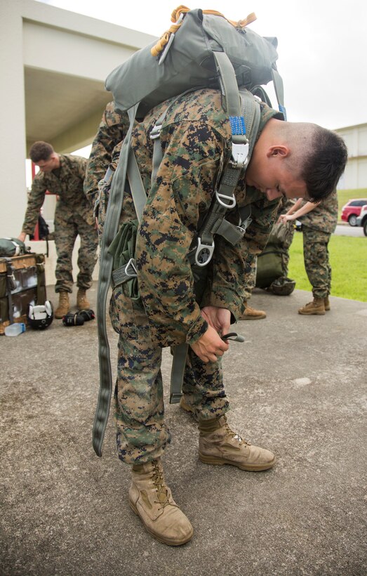 Lance Cpl. Connor Marrow straps on his MC-6 parachute in preparation for his low-level static jump during parachute and air delivery training operations Aug. 14, 2018 at Ie Shima, Okinawa, Japan. The training consisted of low-level static line and military free fall jumps at 10,000 feet in order to keep the Marines proficient as parachute riggers and air delivery specialists. Marrow, a native of Philadelphia, Pennsylvania, is a parachute rigger and air delivery specialist with Landing Support Company, 3rd Transportation Support Battalion, 3rd Marine Logistics Group. (U.S. Marine Corps photo by Cpl. Isabella Ortega)