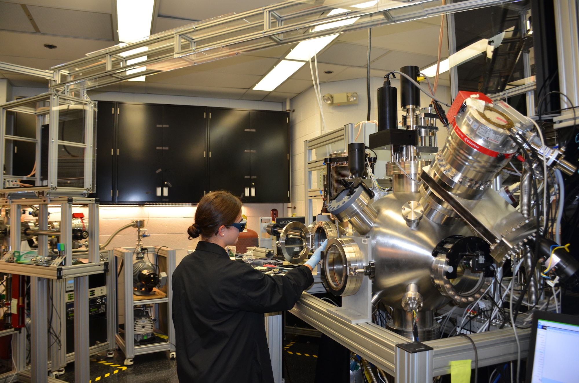 Ashley Wissel, Purdue University undergraduate student, works with the pulsed laser deposition chamber in the Air Force Research Laboratory Materials and Manufacturing Directorate. This is used to study growth of thin layers of material at low temperatures. (U.S. Air Force photo/Donna Lindner)