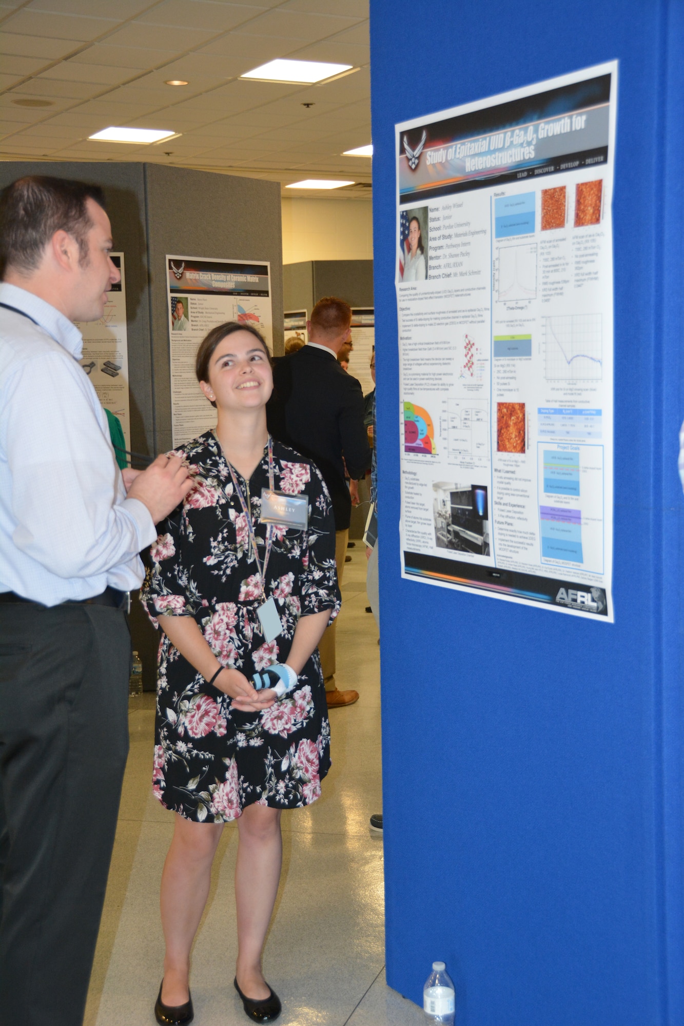 Ashley Wissel, Purdue University undergraduate student, displays her work performed over the summer at a poster session in the Air Force Research Laboratory Materials and Manufacturing Directorate attended by leadership, mentors and colleagues. (U.S. Air Force photo/Dave Dixon)