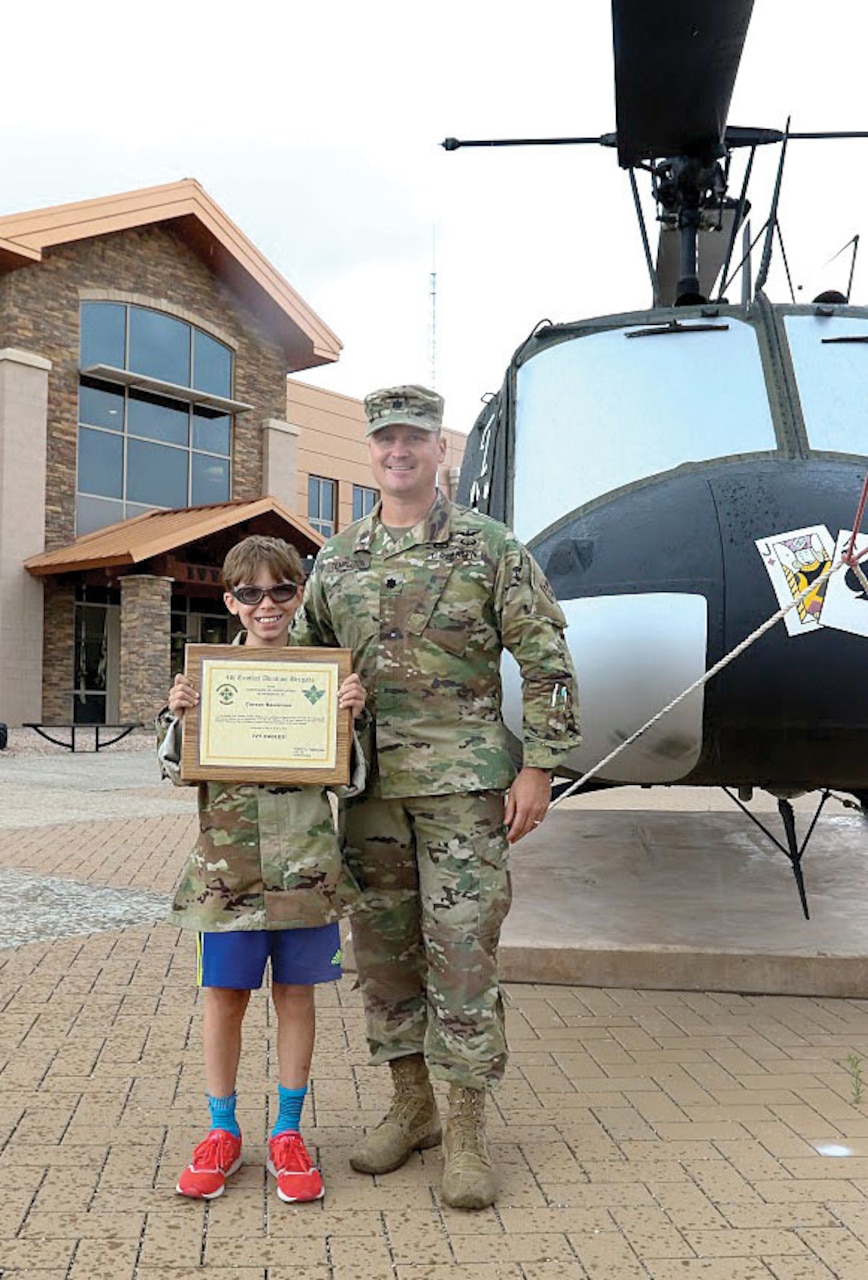 Army Lt. Col. Steven Templeton, commander of the rear detachment of the 4th Combat Aviation Brigade, 4th Infantry Division, presents Carson Raulerson with a certificate of appreciation at Fort Carson, Colo. Army photo by Sgt. Anthony Bryant