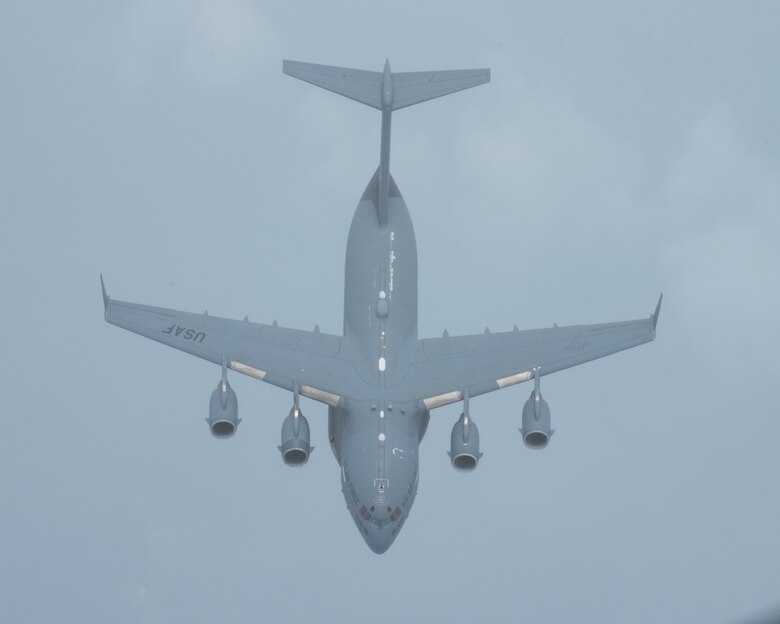 A C-17 Globemaster III with the 437th Airlift Wing, South Carolina flies through the clouds over southeastern United States August 10, 2018. The C-17 was had just finished being refueled by a KC-135 Stratotanker with the 121st Air Refueling Wing, Ohio. (U.S. Air National Guard photo by Airman 1st Class Tiffany A. Emery)