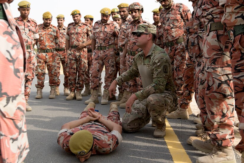 U.S. Army Capt. Ken Ginther, the officer in charge assigned to the 157th Military Engagement Team, Wisconsin Army National Guard, attached to U.S. Army Central, shares his preferred method of detaining and searching a suspect with soldiers from the Royal Army of Oman's Border Guard Brigade at a vehicle control point practical exercise held in Haima, Oman, Aug. 8, 2018. Exercises like this increase interoperability and build relationships between the U.S. Army and partner nation forces in USARCENT's area of operations.