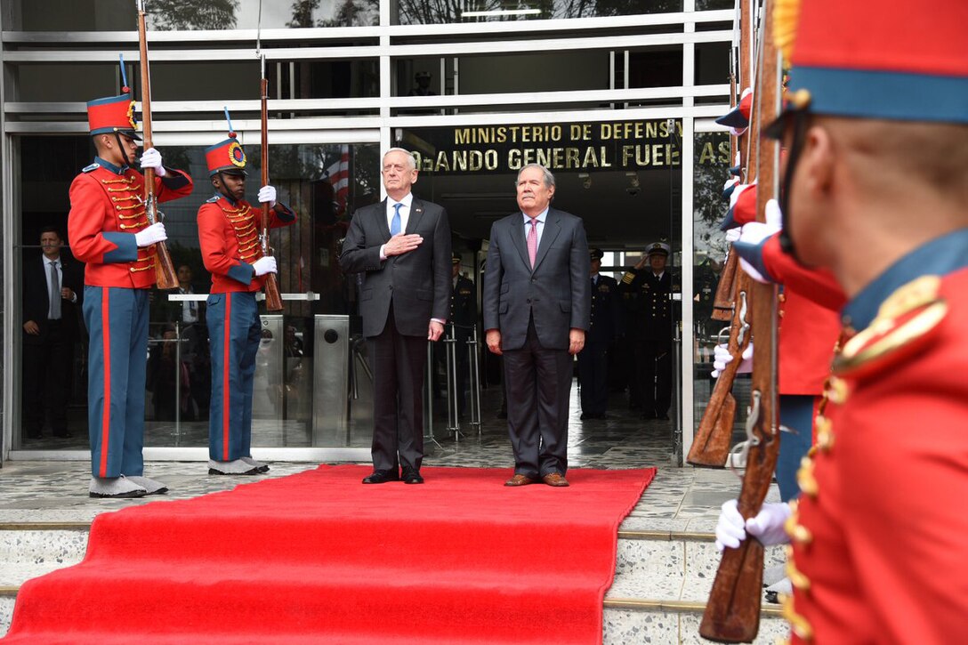 Defense Secretary James N. Mattis and Colombian Defense Minister Guillermo Botero stand at attention.