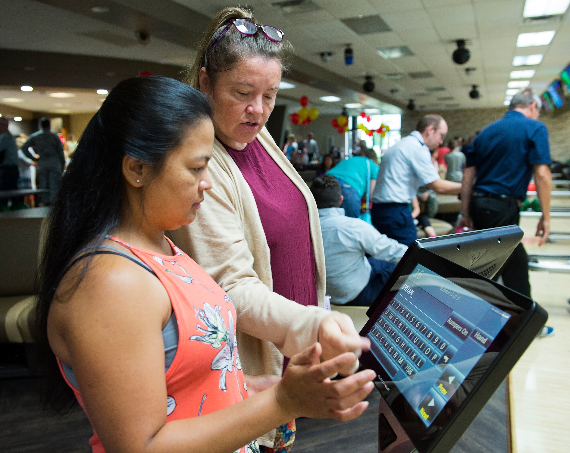 Deloris Wurn helps Jesusa Burdick with the new electronic scoring system at the Wright-Patterson Air Force Base, Ohio, Bowling Center Aug. 13, 2018, shortly after the ribbon cutting for the centers grand reopening.