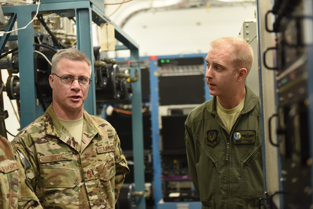 U.S. Air Force Chief Master Sgt. Gregory Smith, left, command chief master sergeant of Air Force Special Operations Command, tours the 193rd Special Operations Wing, Middletown, Pennsylvania, Aug. 16, 2018. Smith’s first stop on the base tour was the partial task trainer where Staff Sgt. Brian Candage, airborne mission system operator with the 193rd SOW, described future updates coming to the EC-130J Commando Solo aircraft special missions equipment. Smith visited in an effort to learn more about the 193rd SOW mission and have the opportunity to meet Air Commandos from across the wing and thank them for their hard work in support of AFSOC. (U.S. Air National Guard photo by Senior Airman Julia Sorber/Released)