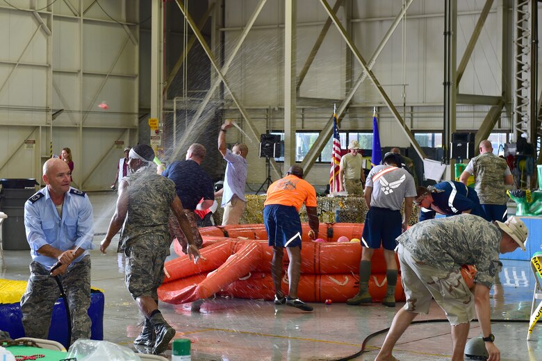 Chief Master Sgt. Hubbell, 434th Logistics Readiness Squadron vehicle management superintendent, sprays a hose at other attendees while other Airmen from the 434th Air Refueling Wing fill water pistols during a combat dining in at Grissom Air Reserve Base, Ind., Aug. 18, 2018. Grissom held its first combat dining in since 2007, where Airmen faced several fun challenges and were encouraged to show off their homemade uniforms. (U.S. Air Force Photo / Staff Sgt. Christopher Massey)