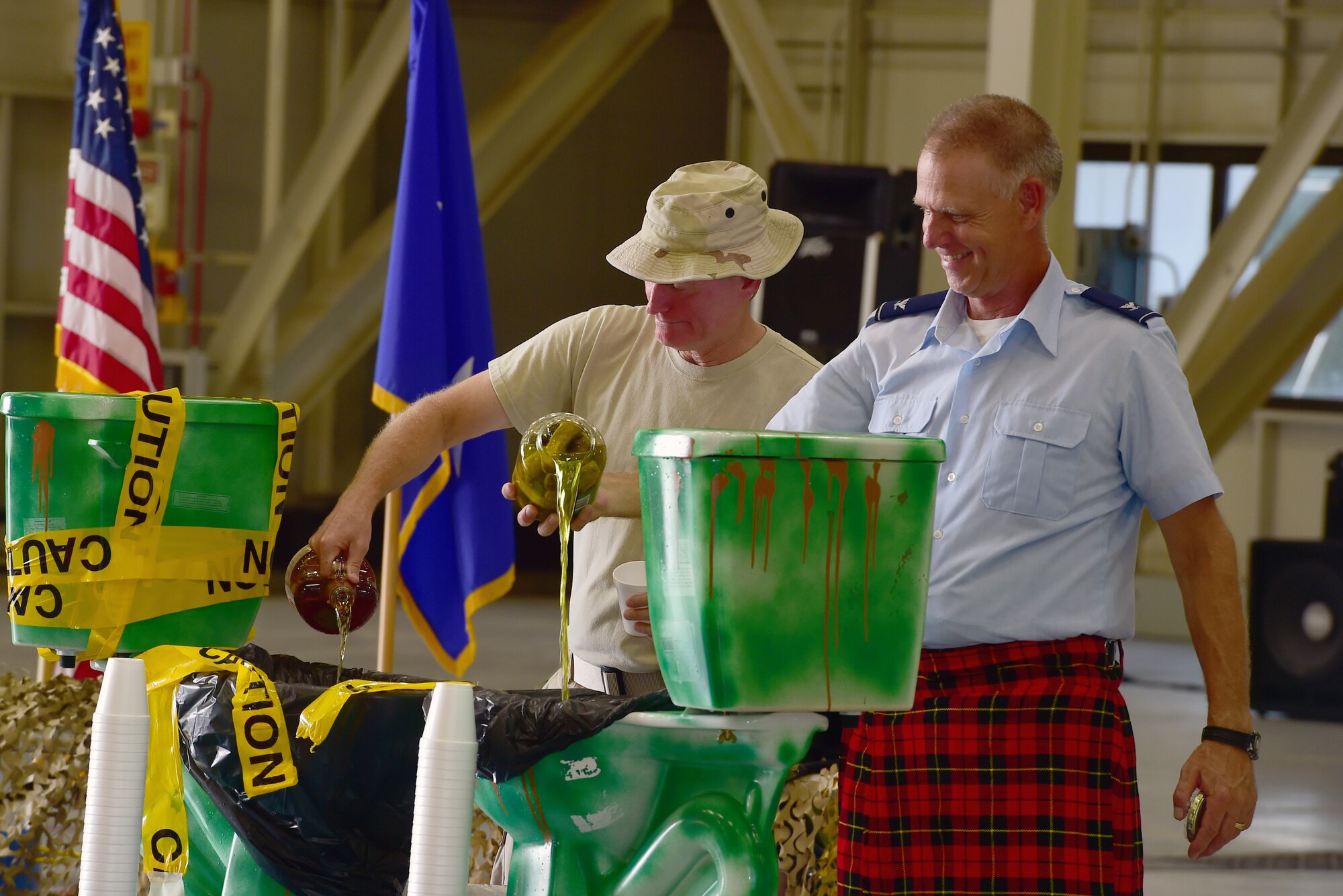 Maj. Gen. Ken Lewis, Air Force Reserve Command director of air space and information operations, and Col. Larry Shaw, 434th Air Refueling Wing commander, charge the Grog to commence a combat dining in at Grissom Air Reserve Base, Ind., Aug. 18, 2018. Grissom held its first combat dining in since 2007, where Airmen faced several fun challenges and were encouraged to show off their homemade uniforms. (U.S. Air Force Photo / Staff Sgt. Christopher Massey)