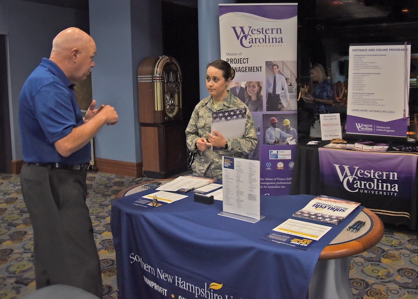Airman 1st Class Emily Gaster, 11th Medical Group cardiopulmonary lab technician, speaks with Chris McCollor from Southern New Hampshire University during an education fair at Joint Base Andrews, Md., Aug. 16, 2018. Prospective students were able to walk between the booths set up by the different schools and have one-on-one conversations with representatives. (U.S. Air Force photo by Senior Airman Abby L. Richardson)