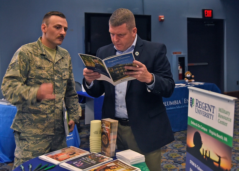 Senior Airman Alan Daniels, 11th Medical Group cardiopulmonary lab technician, speaks with Bill Snow from Regent University during an education fair at Joint Base Andrews, Md., Aug. 16, 2018. At each booth, prospective students learned about topics such as admissions processes, degree programs and school offerings. (U.S. Air Force photo by Senior Airman Abby L. Richardson)