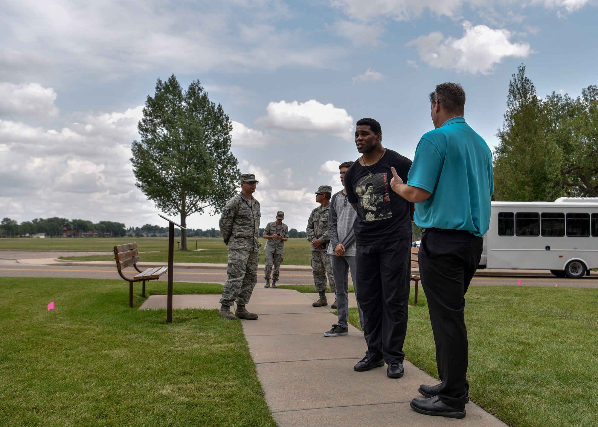 Herschel Walker, 1982 Heisman Trophy winner, listens to Glenn Robertson, 90th Missile Wing tour guide, during a tour of F.E. Warren Air Force Base, Wyo., Aug. 14, 2018. During the tour, Walker learned about the rich history of F.E. Warren AFB. (U.S. Air Force photo by Airman 1st Class Braydon Williams)