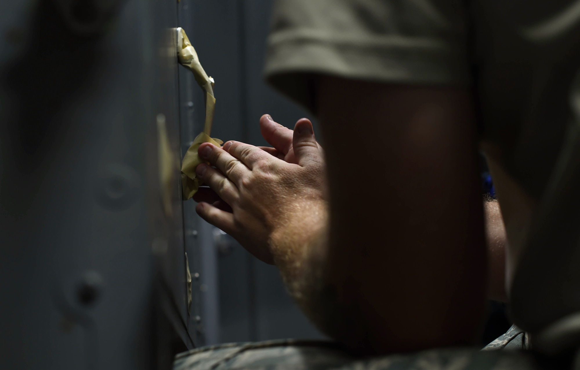 Staff Sgt. Cody Lange, 60th Maintenance Squadron aircraft structural maintenance technician, applies masking tape to certain areas before painting the inside of a C-17 Globemaster III from Travis Air Force Base, Calif., Aug. 6, 2018, at Joint Base Lewis-McChord, Wash. Travis and McChord Airmen are trying to build a partnership where Travis C-17s are painted in McChord’s paint barn. (U.S. Air Force photo by Senior Airman Tryphena Mayhugh)