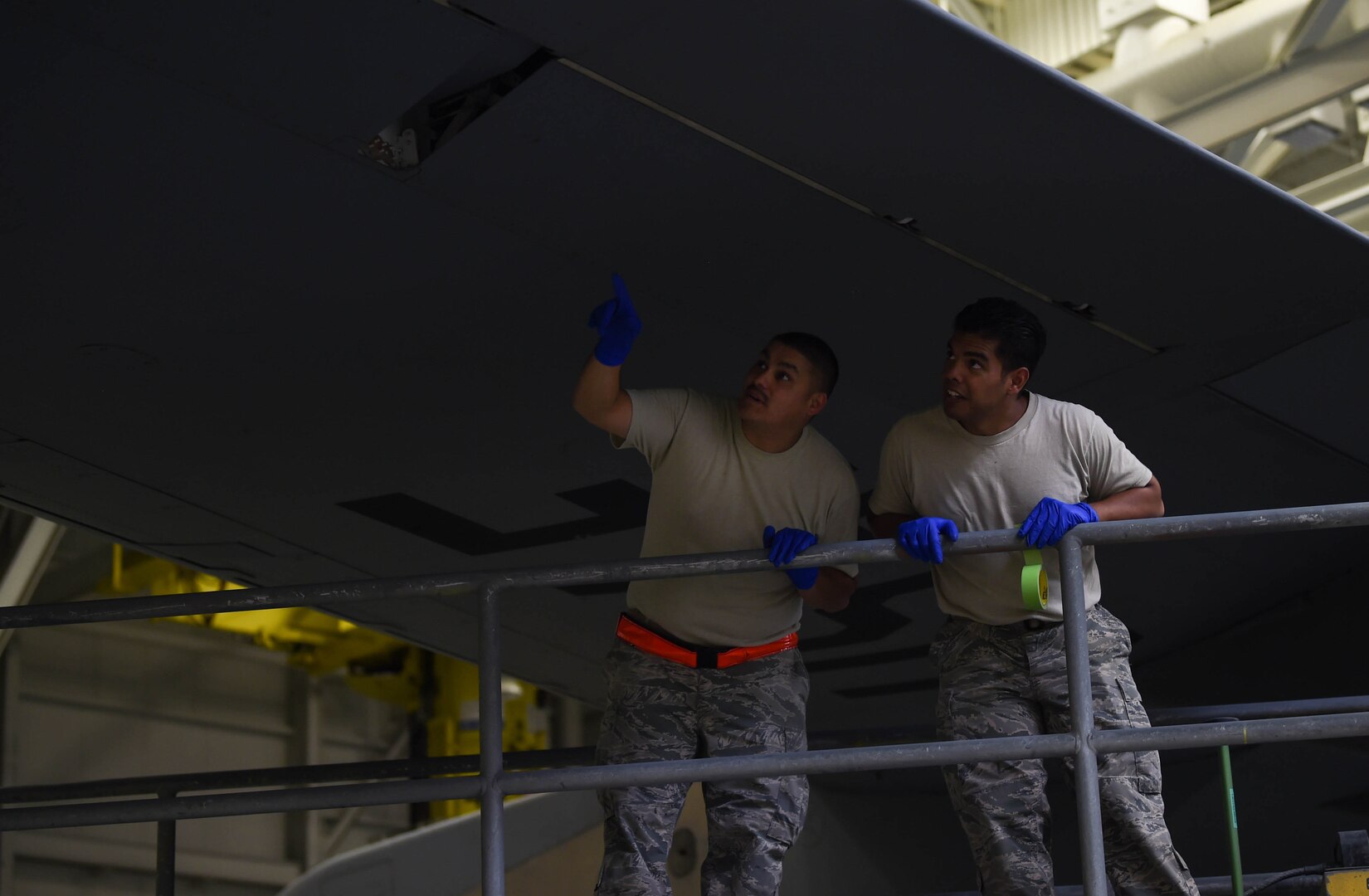 Tech. Sgt. Salvador Ynostraza, left, and Staff Sgt. Adrian Catalan, both 60th Maintenance Squadron aircraft structural maintenance technicians, assess the wing of a C-17 Globemaster III from Travis Air Force Base, Calif., for bare paint spots Aug. 6, 2018, at Joint Base Lewis-McChord, Wash. Ynostraza and Catalan were part of a Travis crew sent to McChord to spray paint their C-17 in McChord’s paint barn.  (U.S. Air Force photo by Senior Airman Tryphena Mayhugh)