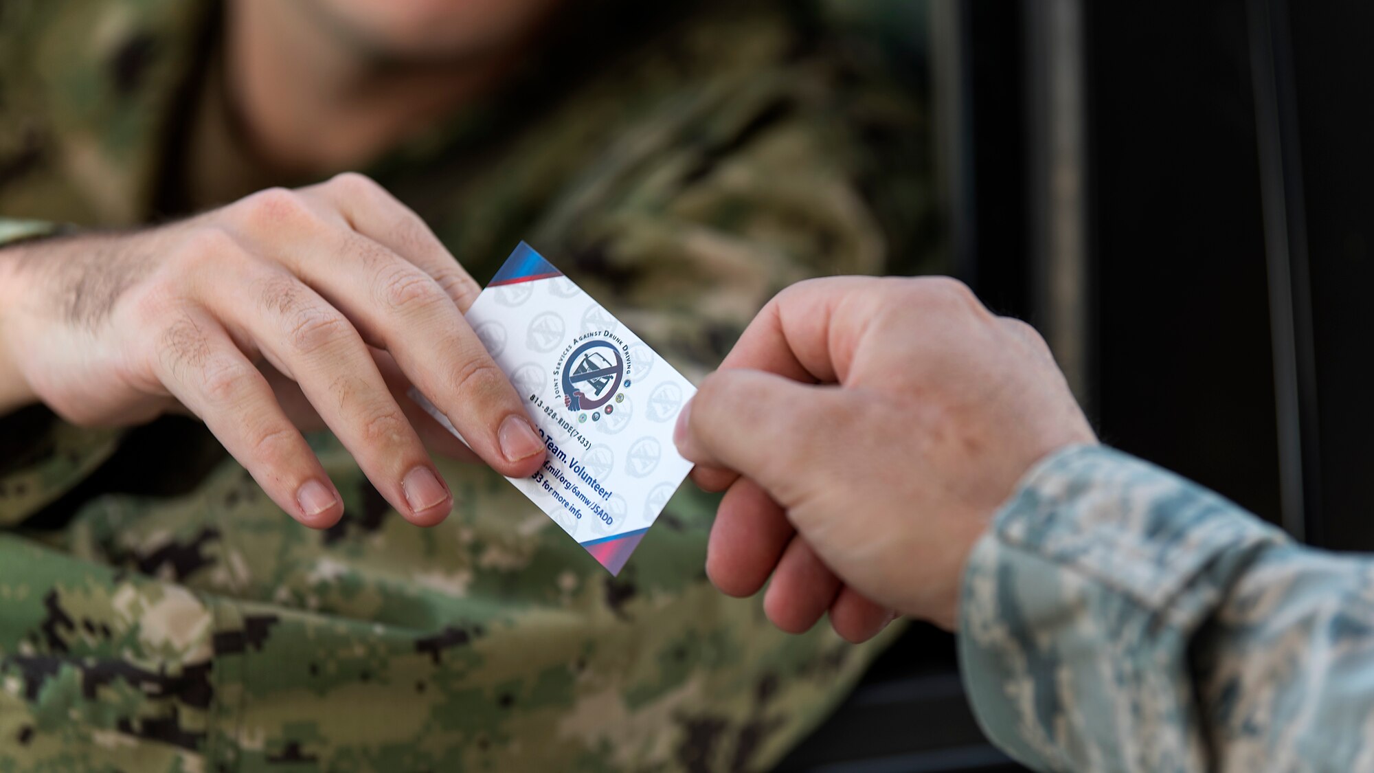 A U.S. Navy sailor takes a Joint Services Against Drunk Driving card at MacDill Air Force Base, Fla., Aug. 17, 2018. JSADD offers a free, anonymous and safe alternate mode of transportation for those who have been drinking and are unable to secure a ride home with a single phone call to 813 – 828 – RIDE (4473)