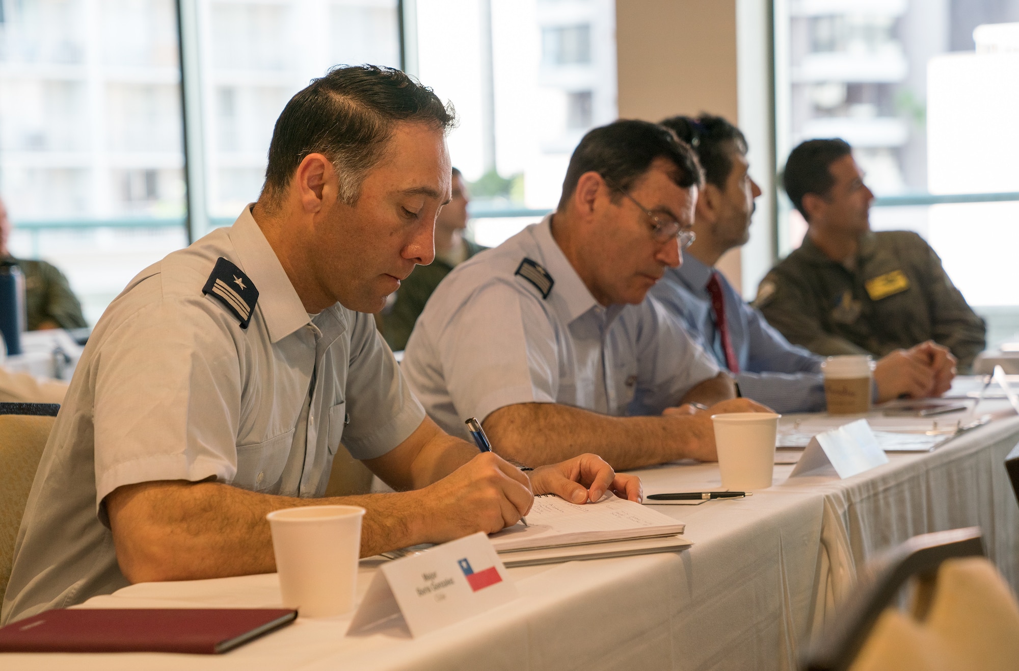 Chilean air force Maj. Boris Gonzalez (left) and Chilean air force Col. Sergio Figueroa (right) take notes during the resource and risk management presentation of the Asia-Pacific Aviation Safety Subject Matter Expert Exchange (APASS) in Honolulu, Hawaii, Aug. 14, 2018. APASS allows partner nations to discuss aviation safety practices and devise solutions to challenges faced by the various air forces. (U.S. Air Force photo by Staff Sgt. Daniel Robles)