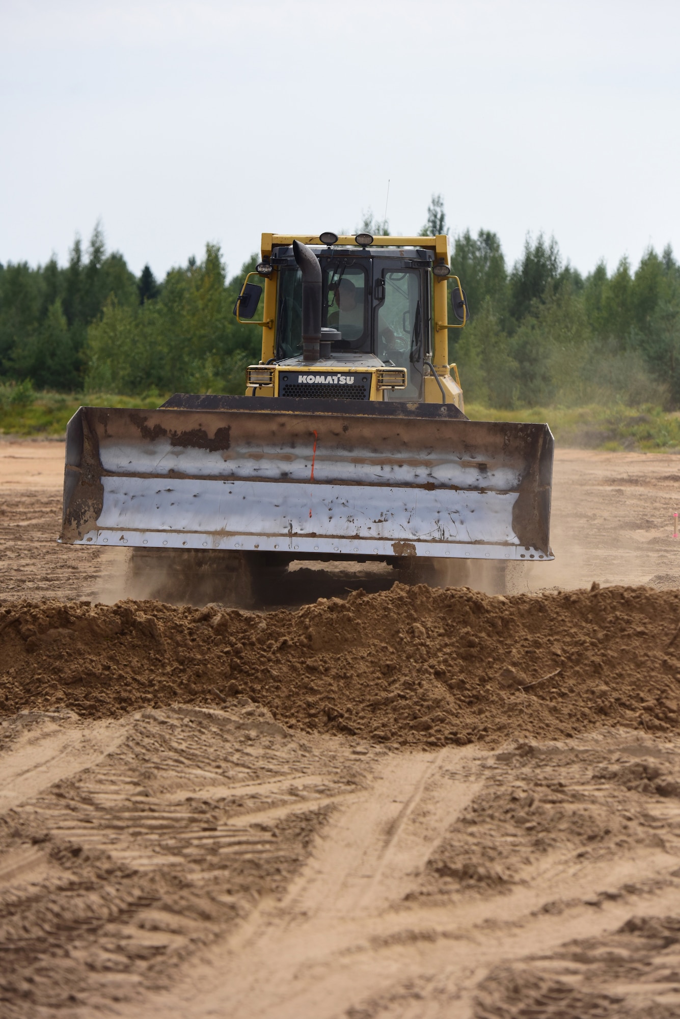 Tech. Sgt. Jacob Wallace, airfields team lead with the 201st Rapid Engineer Deployable Heavy Operational Repair Squadron Engineers, operates a bulldozer to clear the ground in the process of creating a military air-to-ground training range at Brigadier General Kazio Veverskis Training Grounds, Kazlu Ruda, Lithuania, Aug. 14, 2018. The range will include a mock village, bomb circle, simulated runway, fire break, strafe pit and an observation point to be used by Lithuanian and other NATO forces. (U.S. Air National Guard photo by Tech. Sgt. Claire Behney/Released)