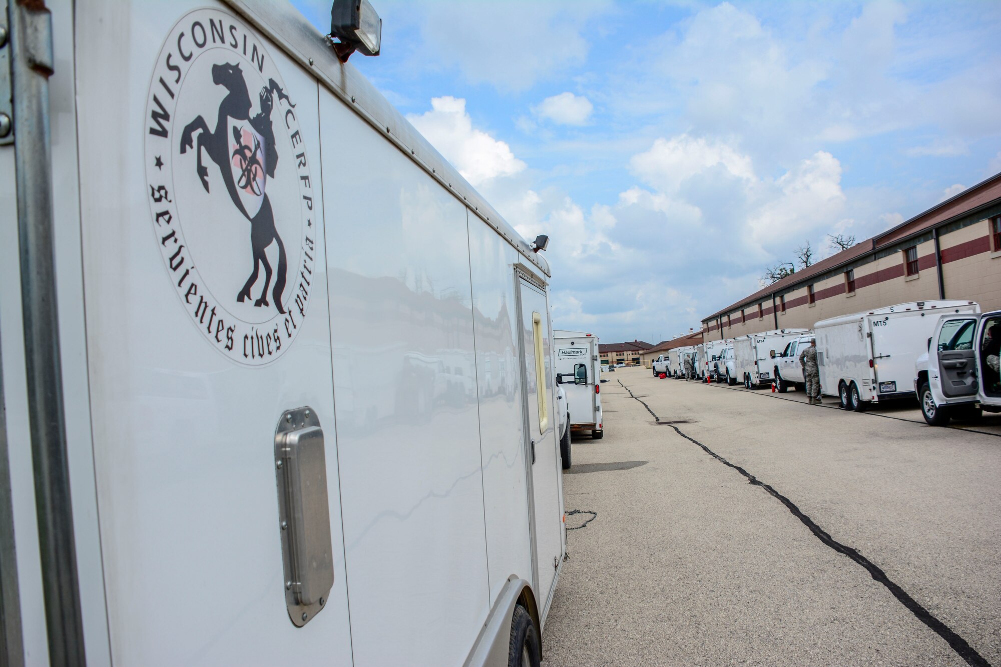 Vehicles with the Wisconsin Chemical, Biological, Radiological, Nuclear and High Yield Explosive Enhanced Response Force Package park in an alley waiting to move to their specified locations for the External Evaluation exercise at Volk Field Air National Guard Base, Aug. 16, 2018. The ExEval is conducted as a way to re-validate the WI CERFP to perform its CBRN Response Enterprise mission in support of the State and Nation. (U.S. Air National Guard photo by Tech. Sgt. Mary E. Greenwood)