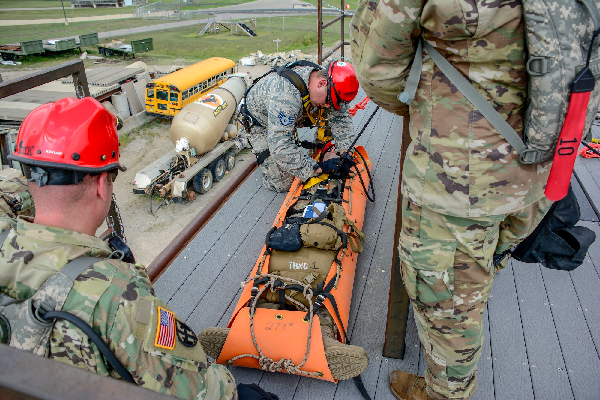 Joint military members with the Wisconsin Chemical, Biological, Radiological, Nuclear and High Yield Explosive Enhanced Response Force Package Medical Group prep a soldier for a sked drop over the side of a building as part of the 2018 External Evaluation exercise at Volk Field Air National Guard Base, Aug. 16, 2018. The ExEval is conducted as a way to re-validate the WI CERFP to perform its CBRN Response Enterprise mission in support of the State and Nation.(U.S. Air National Guard photo by Tech. Sgt. Mary E. Greenwood)