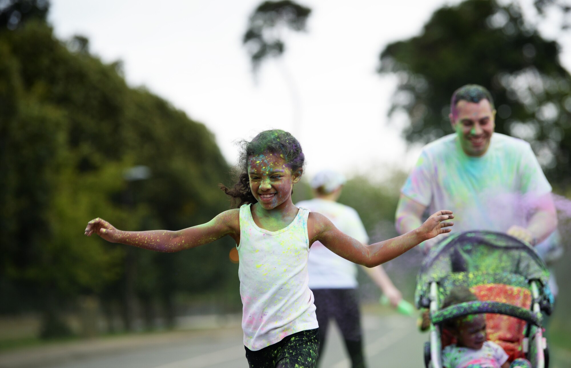 A child runs ahead of her family to the finish line of a color dash at Royal Air Force Lakenheath, England, Aug. 18, 2018. The color dash provided RAF Lakenheath and RAF Mildenhall families an opportunity to unite in fun activities before the start of the school year. (U.S. Air Force photo/Airman 1st Class Shanice Williams-Jones)