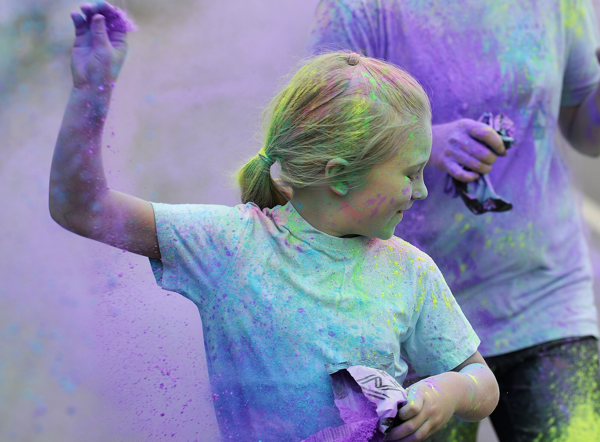 A child runs through the colored chalk at a color dash at Royal Air Force Lakenheath, England, Aug. 18, 2018. Participants showed up in white to get the most of their color dash experience. (U.S. Air Force photo/Airman 1st Class Shanice Williams-Jones)