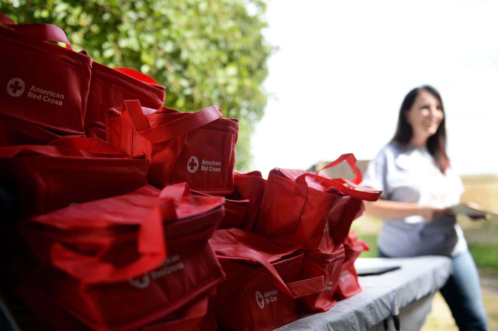 Souvenir bags are compiled on a table to present to all Red Cross youth volunteers at the Summer Youth Program’s end of summer barbeque, Royal Air Force Lakenheath, England, Aug. 17, 2018. American Red Cross RAF Lakenheath-RAF Mildenhall team hosted the six-week program to teach youth volunteers accountability, professionalism and teamwork in various settings around the military base. (U.S. Air Force photo/Airman 1st Class Shanice Williams-Jones)