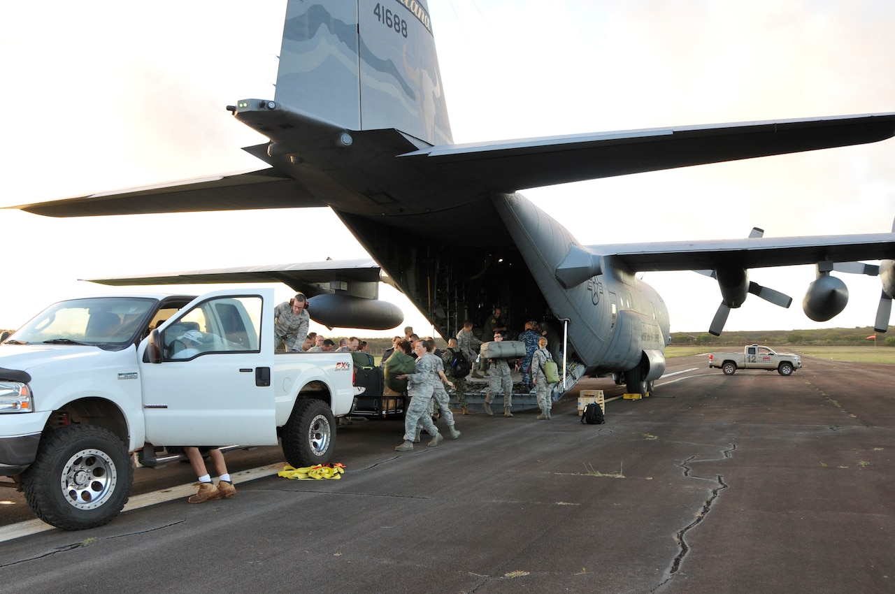 Service members from the Air National Guard and Navy Reserve unload equipment from a C-130 Hercules aircraft after arriving in Molokai, Hawaii, for Tropic Care Maui County 2018, Aug. 10, 2018. Tropic Care Maui County 2018 is a joint-service training mission offering no cost medical, dental, and vision services to people at six locations across Maui, Molokai and Lanai. Air National Guard photo by Air Force Staff Sgt. Lonnie Wiram