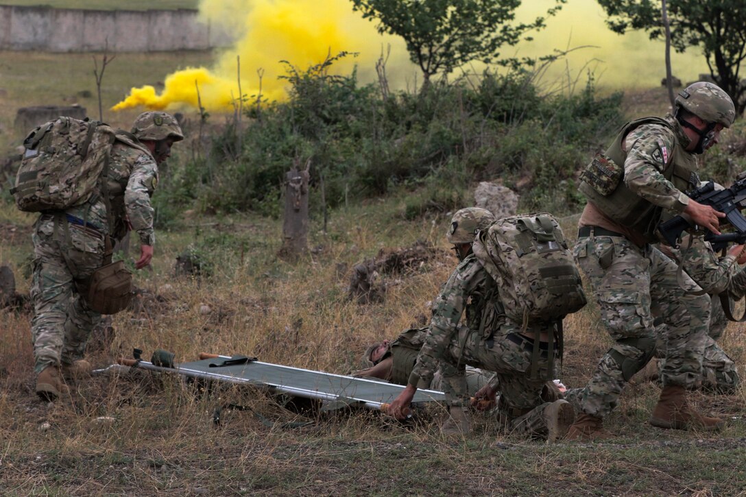 Georgian soldiers provide cover for medics preparing to transport a simulated casualty.