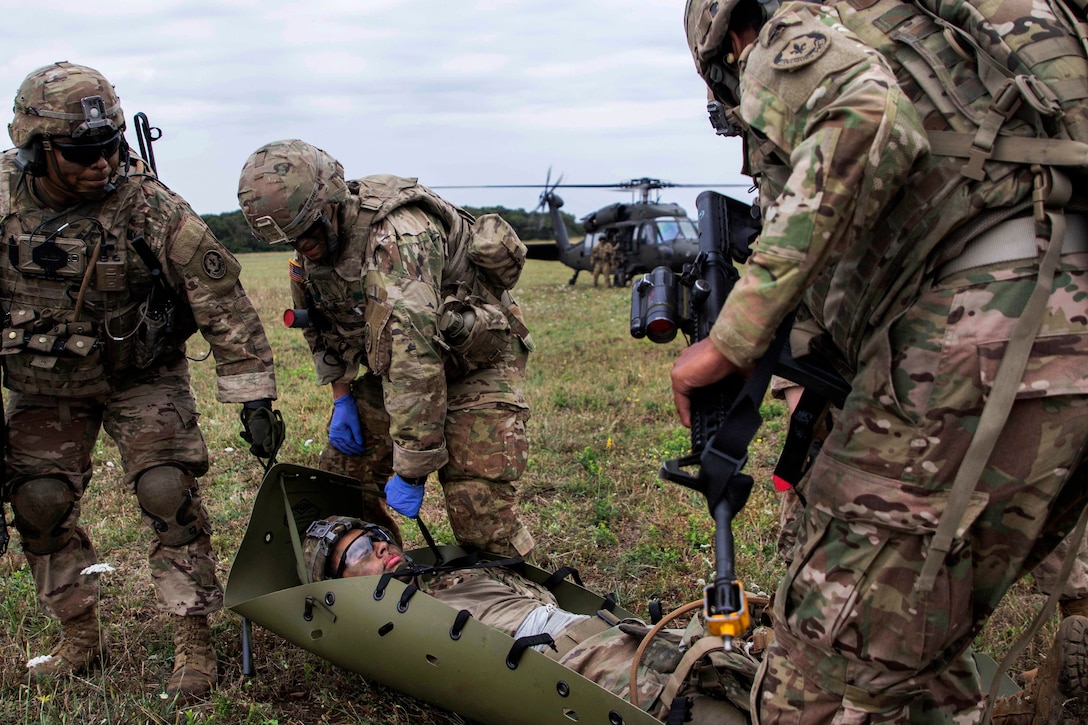 Soldiers prepare to move a simulated casualty to a UH-60 Black Hawk helicopter to be evacuated.