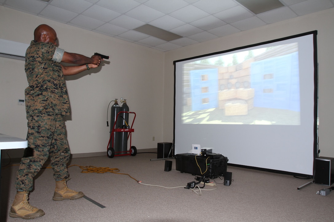 Marine Corps Logistics Base Albany Commanding Officer Col. Alphonso Trimble (right) test out an active shooter simulator aboard Marine Corps Logistics Base Albany, August 8. Marine Corps Police Department recently purchased the simulator to test officers' ability to make decisions during intense situations. It also prepares officers for real-life scenarios such as traffic stops and active shooter events. (U.S. Marine Corps photo by Re-Essa Buckels)