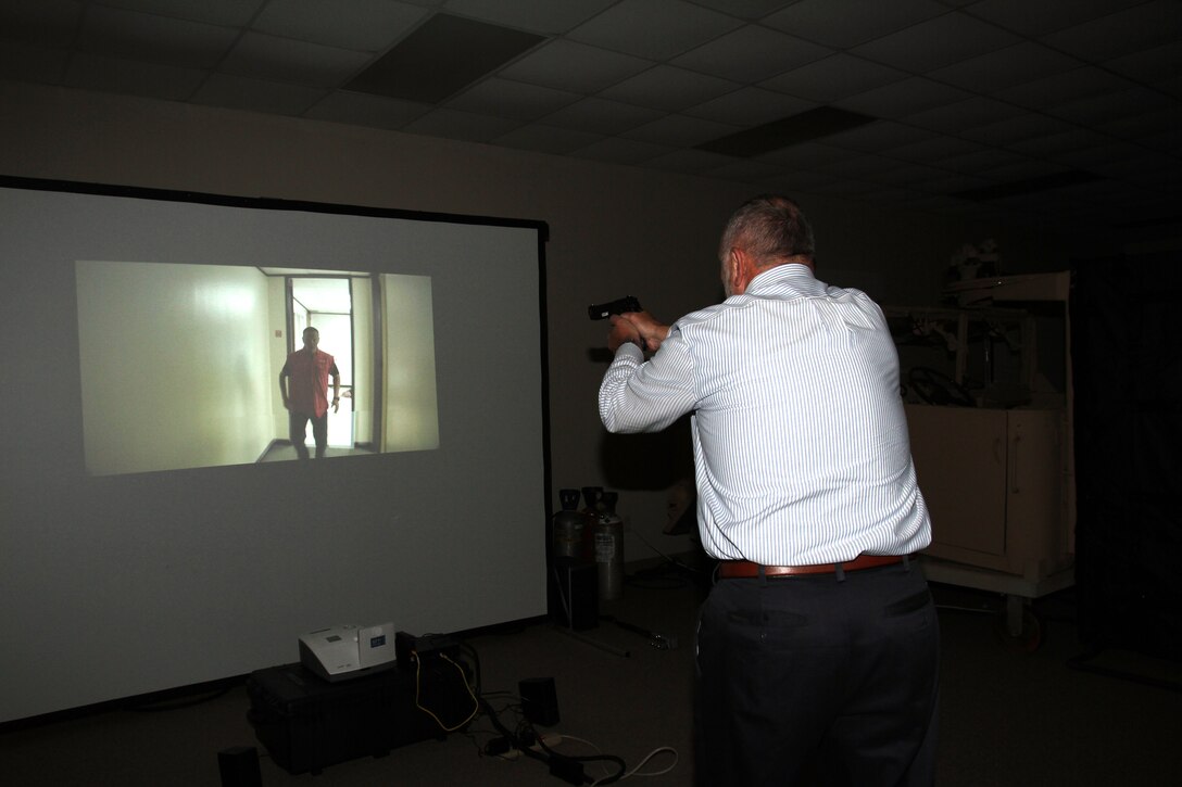 Kent Morrison, Executive Director, the Operations and Training Division, tests out an active shooter simulator aboard Marine Corps Logistics Base Albany, August 8. Marine Corps Police Department recently purchased the simulator to test officers's ability to make decisions during intense situations. It also prepares officers for real-life scenarios such as traffic stops and active shooter events. (U.S. Marine Corps photo by Re-Essa Buckels)