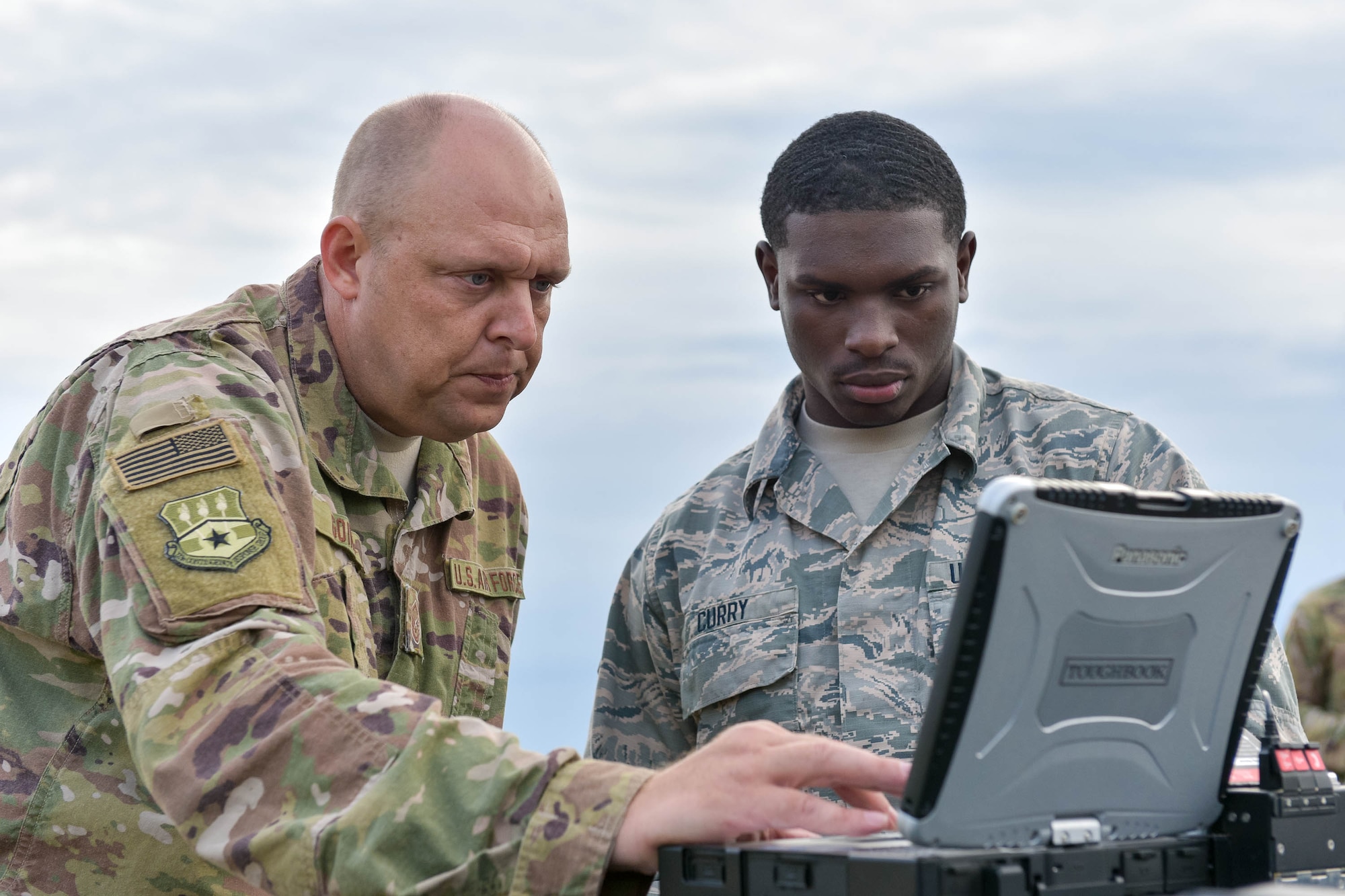 Master Sgt. Kyle Goins (left) and Airman First Class Keontay Curry, both communications specialists assigned to the Kentucky Air National Guard’s 123rd Contingency Response Group, set up computer systems for Operation Huron Thunder at the Alpena Combat Readiness Training Center in Alpena, Mich., July 22, 2018. The 123rd CRG worked in conjunction with the U.S. Army’s 690th Rapid Port Opening Element to operate a Joint Task Force-Port Opening during the exercise. The objective of the JTF-PO is to establish a complete air logistics hub and surface distribution network. (U.S. Air National Guard photo by Maj. Allison Stephens)