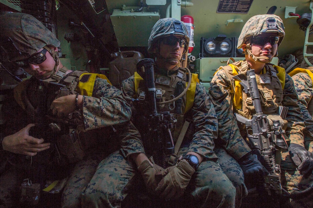 Marines sit in the back of an amphibious assault vehicle transporting them to their next objective.