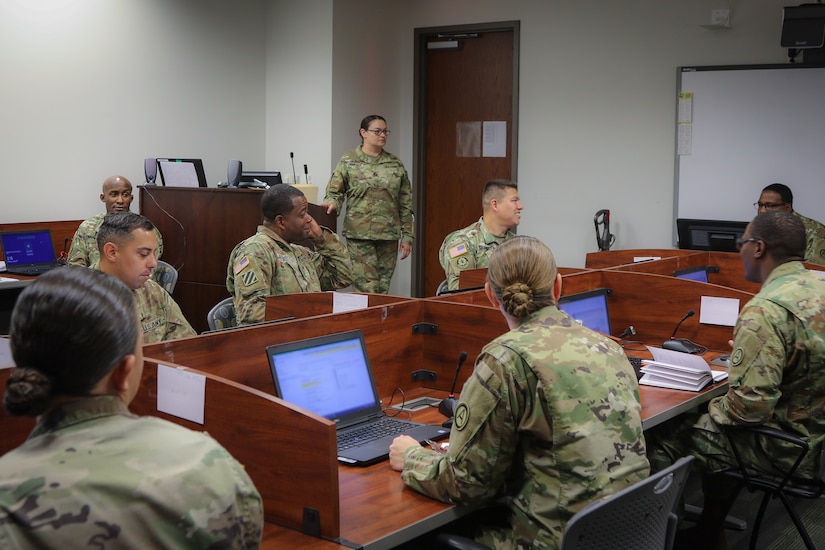 Sgt. 1st Class Brooke Crytser (standing center), an assistant instructor for the U.S. Army Battle Staff Noncommissioned Officers Course and a personnel recovery intelligence NCO at U.S. Army Central, engages with students enrolled in the course at USARCENT headquarters on Shaw Air Force Base, S.C., July 27, 2018. BSNCOC provides technical and tactical curriculum relevant to the missions, duties and responsibilities assigned to battle staff members.