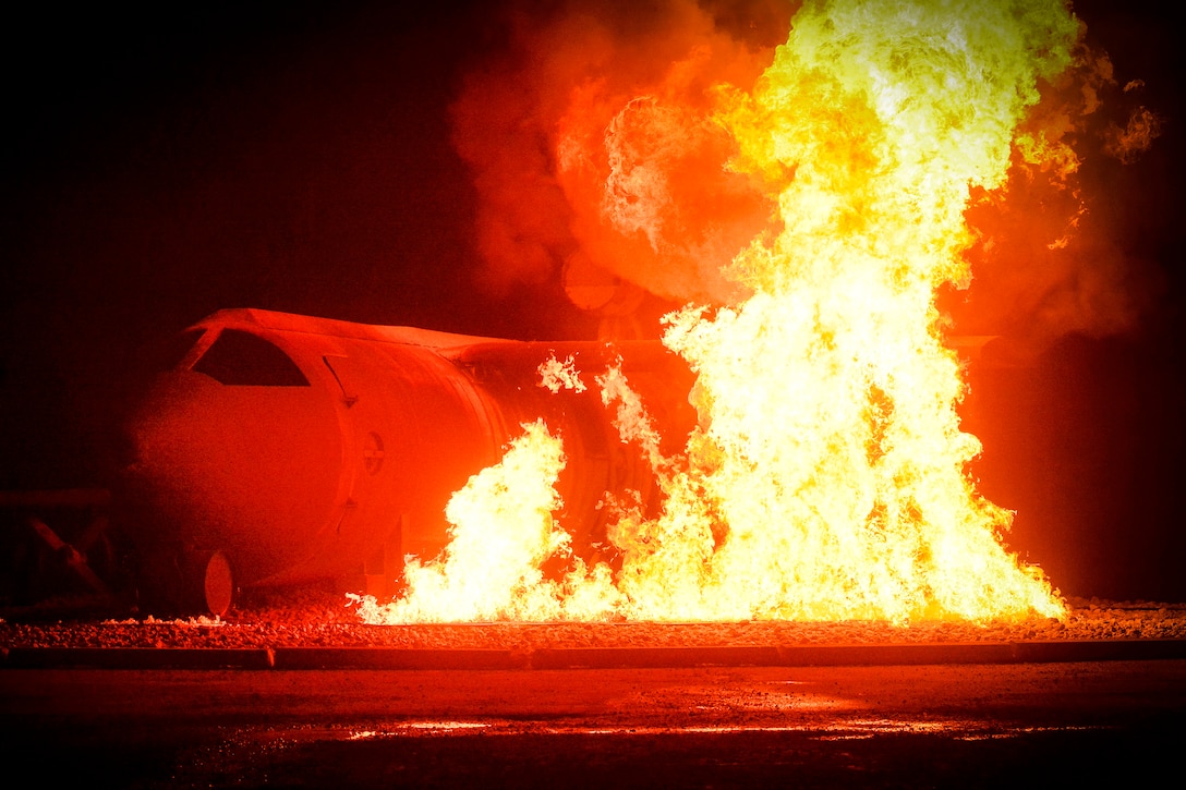 U.S. and coalition troops combat a simulated aircraft fire during a night burning exercise.