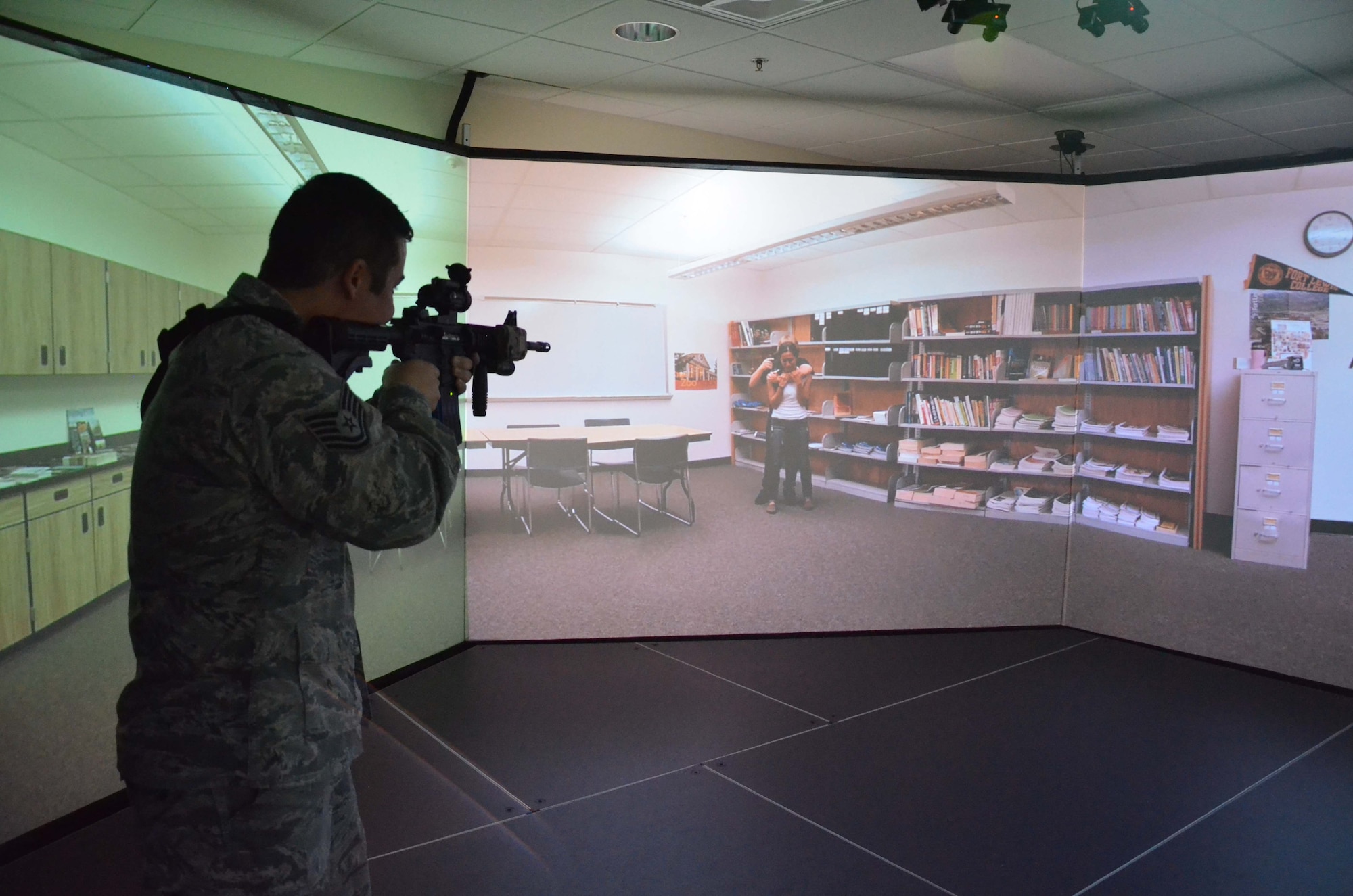 Tech. Sgt. Scott Buske, a spectral analysis section chief with the 21st Surveillance Squadron, Air Force Technical Applications Center, Patrick AFB, Fla., takes aim at a virtual active shooter using VirTra, a 300-degree wrap-around simulator used by members of the 45th Security Forces Squadron.  Buske and 17 members of his squadron spent a day with the law enforcement agents to learn more about how they protect the base. (U.S. Air Force photo by Susan A. Romano)