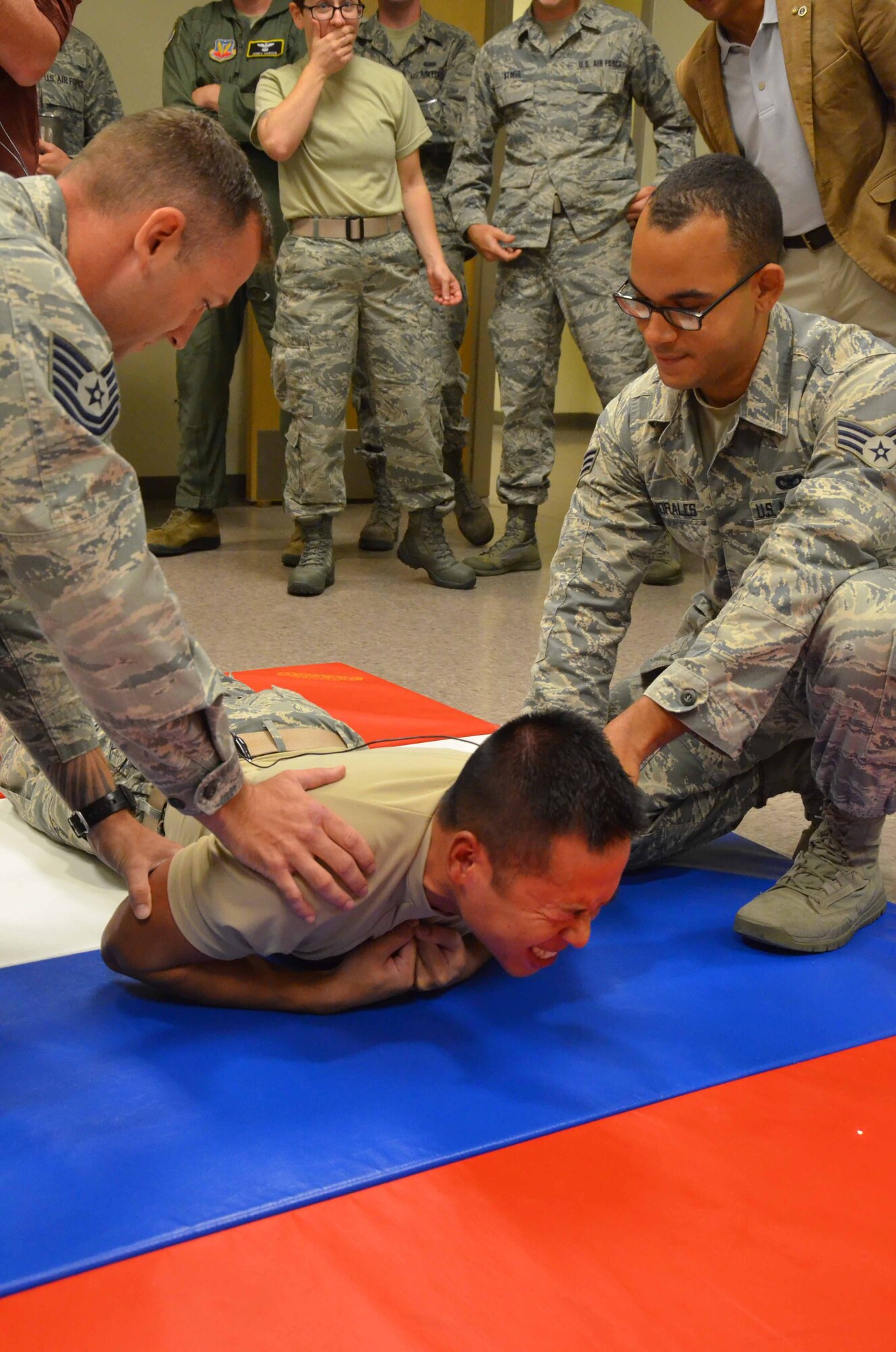 Senior Airman Nam Tran, a deployed analysis system technician with the 21st Surveillance Squadron, reacts to voltage from a conducted electrical weapon delivered by James “Chewy” Chenoweth, a security forces trainer with the 45th Security Forces Squadron.  Tran and 17 other members of his squadron based at Patrick AFB, Fla., spent a day with Airmen of the 45th SFS to learn more about the law enforcement officers who patrol and protect the installation and its people.  (U.S. Air Force photo by Susan A. Romano)