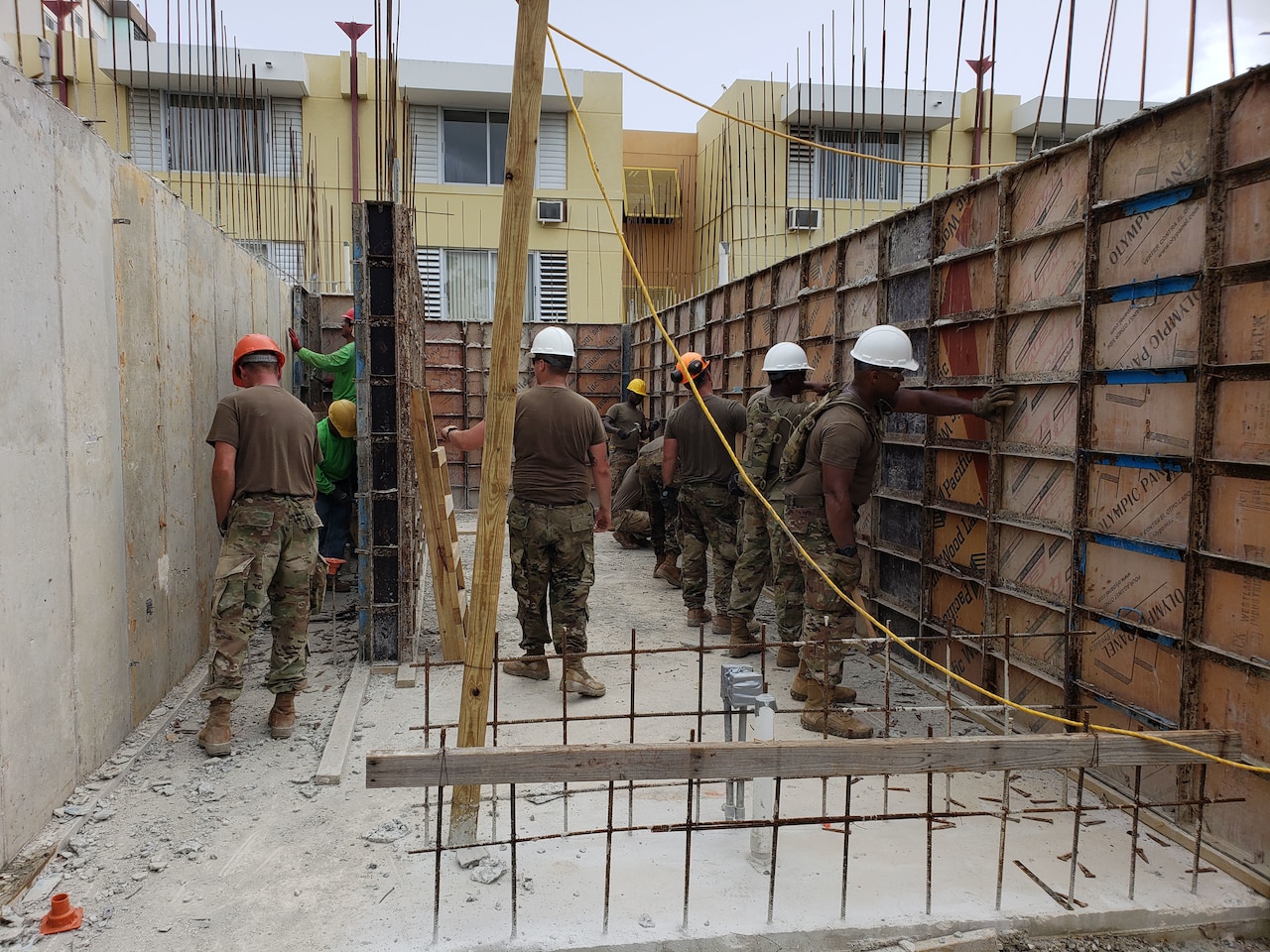 Soldiers help to build a house.