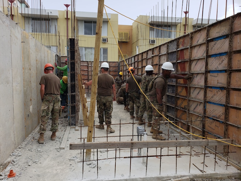 Soldiers help to build a house.