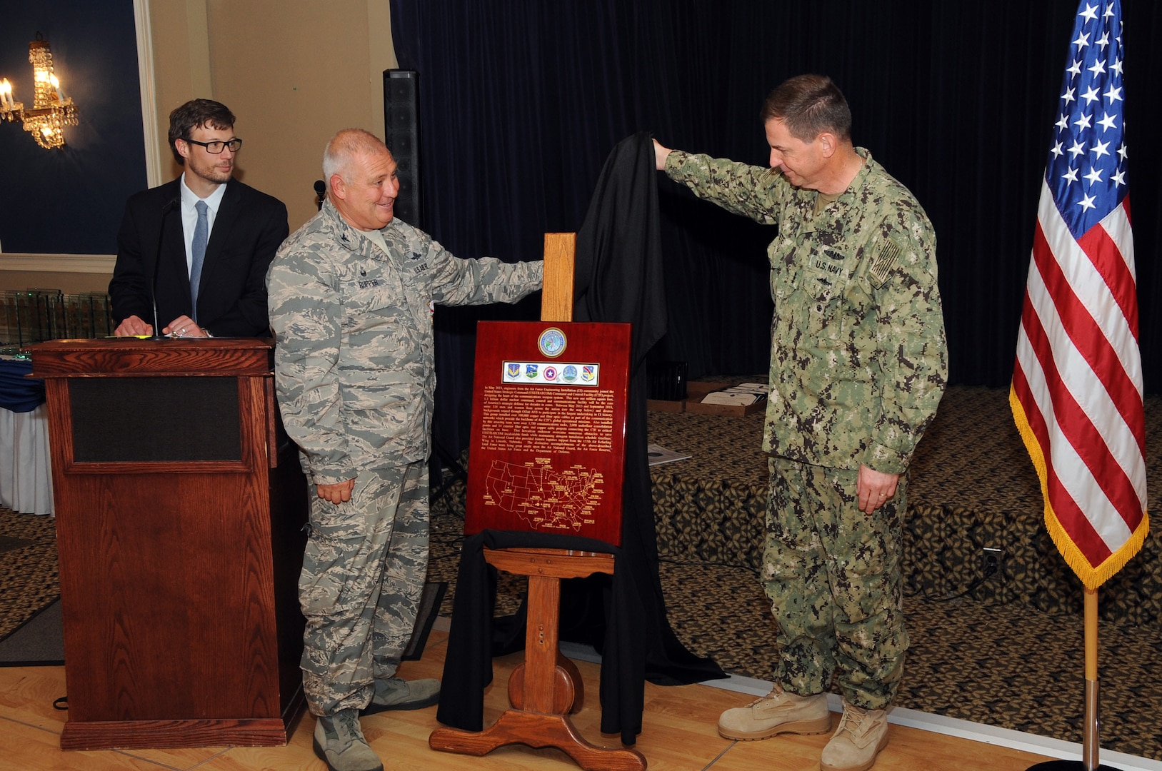U.S. Navy Vice Admiral David M. Kriete, deputy commander of the U.S. Strategic Command (USSTRATCOM), and U.S. Air Force Col. Wade Rupper, commander of the 251st Cyberspace Engineering Installation Group (251st CEIG), present a plaque during a luncheon and ceremony at the Patriot Club on Offutt Air Force Base, Neb., Aug. 6, 2018. The 251st CEIG, the 220th Engineering Installation Squadron, and the total force, United States Air Force engineering installation community were recognized for providing the infrastructure and cable installation for the new USSTRATCOM Command and Control facility over the past five years.
