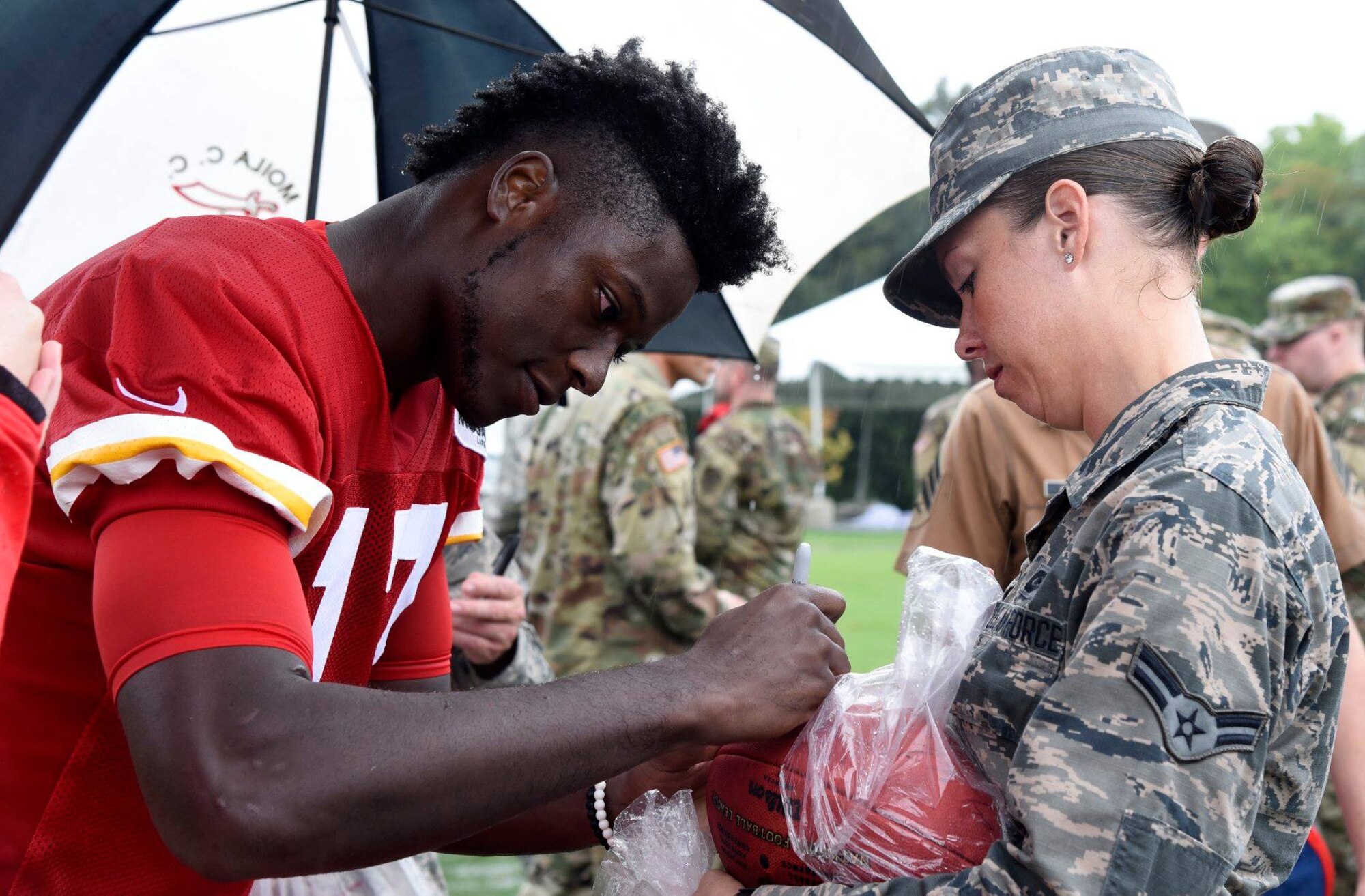 A Kansas City Chiefs player signs a football after military appreciation day at the Chiefs training camp in St. Joseph, Mo., Aug. 14, 2018. The Chiefs invited military members from across Kansas and Missouri  to watch their final training camp practice as well as meet and greet the players.