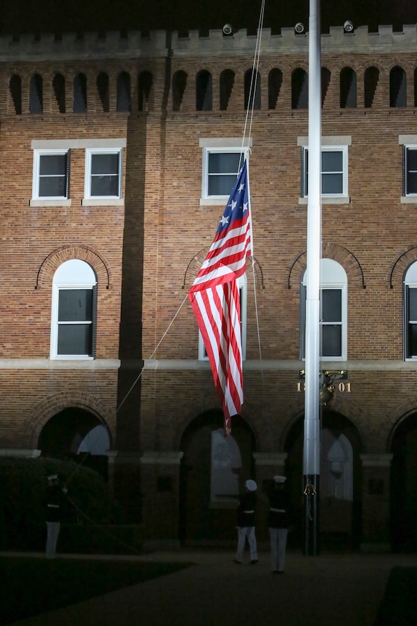 Marines with a Marine Barracks Washington D.C. Colors Team lower the National Ensign during a Friday Evening Parade at Marine Barracks Washington D.C., Aug. 17, 2018. The guest of honor for the parade was the Honorable James F. Geurts, assistant secretary of the Navy for Research, Development and Acquisition and the hosting official was Lt. Gen. Michael G. Dana, director, Marine Corps Staff. (Official Marine Corps photo by Sgt. Robert Knapp/Released)