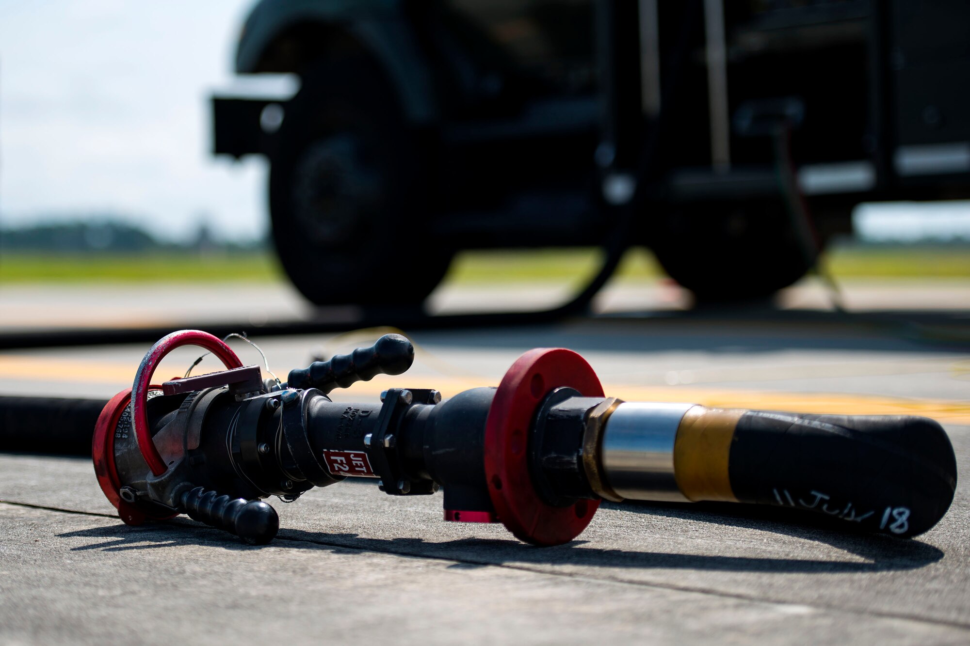 A refuel hose rests on the flightline during a hot pit refueling, Aug. 14, 2018, at Moody Air Force Base, Ga. Members of the 23d Logistics Readiness Squadron preposition fueling trucks to allow aircraft to refuel without needing to shut down. This style of refueling is used to eliminate the need for additional maintenance procedures and to extend pilots’ training time per flight which improves operations tempo. (U.S. Air Force photo by Airman 1st Class Erick Requadt)