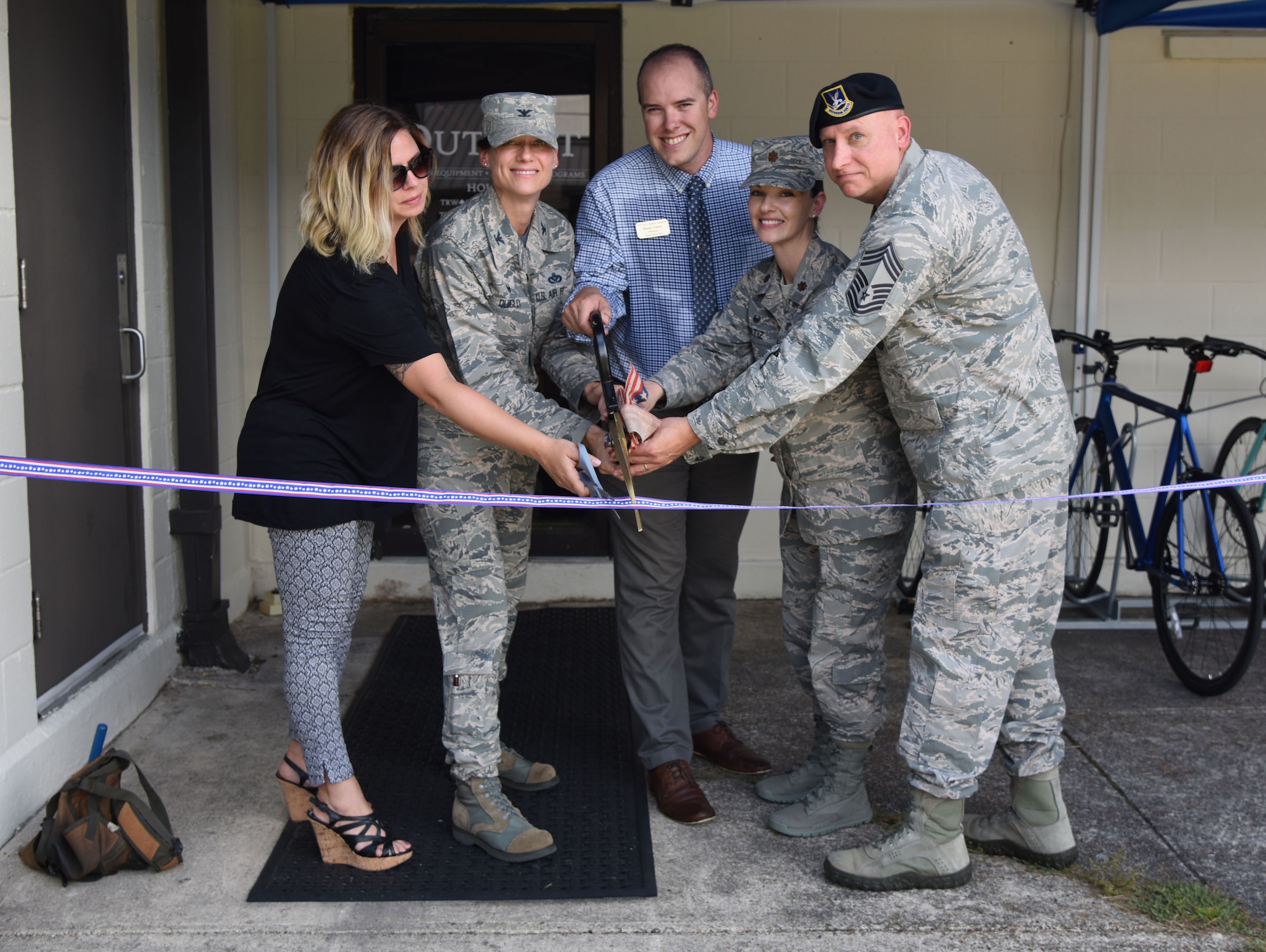 U.S. Air Force Col. Marcia Quigley, 81st Mission Support Group commander, and members of the 81st Force Support Squadron participate in a ribbon cutting ceremony during The Outpost grand opening at the Vandenberg Commons at Keesler Air Force Base, Mississippi, Aug. 17, 2018. The Outpost is a satellite store from the Outdoor Recreation Center with recreation items available for Airmen in the 81st Training Group. (U.S. Air Force photo by Kemberly Groue)