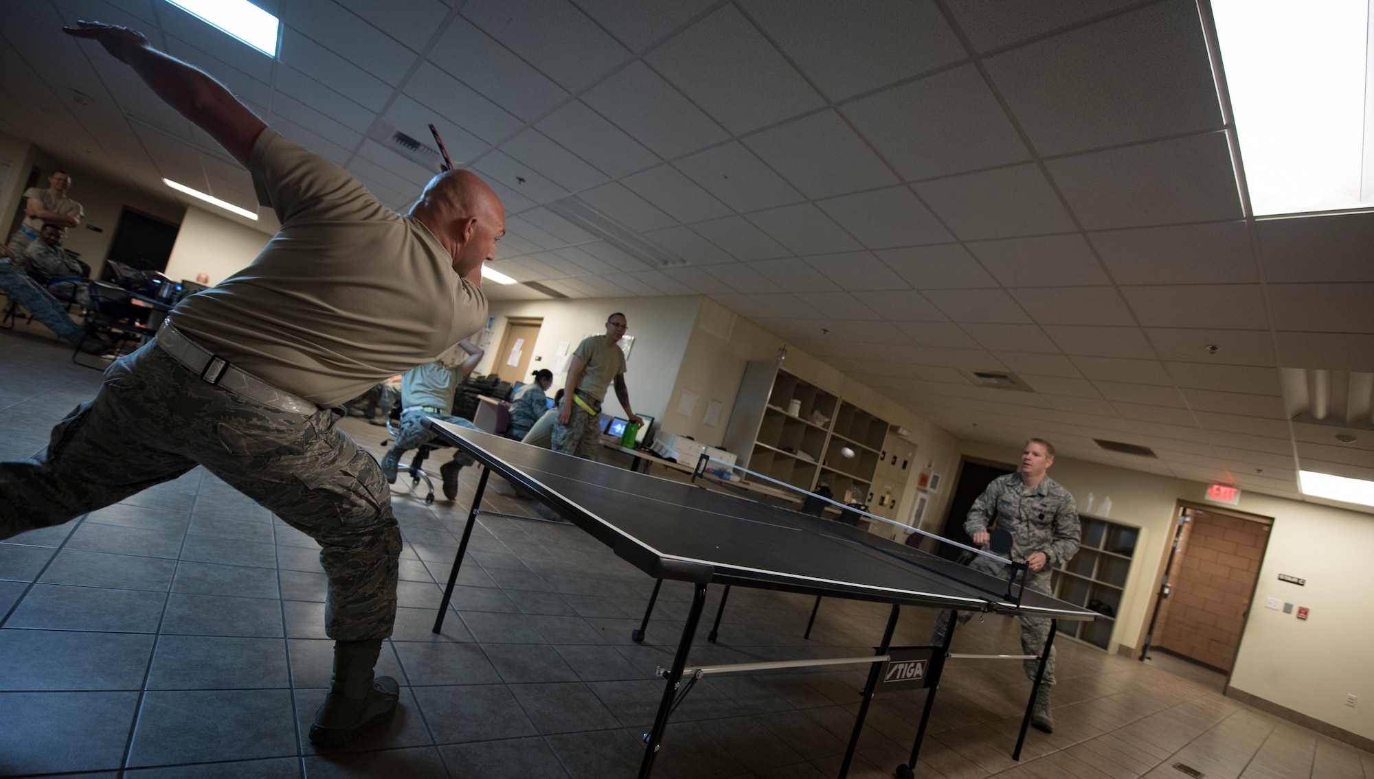 Staff Sgt. Joseph Johnson, 57th Aircraft Maintenance Squadron Lightning Aircraft Maintenance Unit avionics technician, plays table tennis with Staff Sgt. Joshua Harris, 57th AMXS Lightning AMU activity security manager, between shift changes at Nellis Air Force Base, Nevada, July 23, 2018. Airmen usually get time to unwind toward the end of their shift if their tasks are done for the day. (U.S. Air Force photo by Airman 1st Class Andrew D. Sarver)