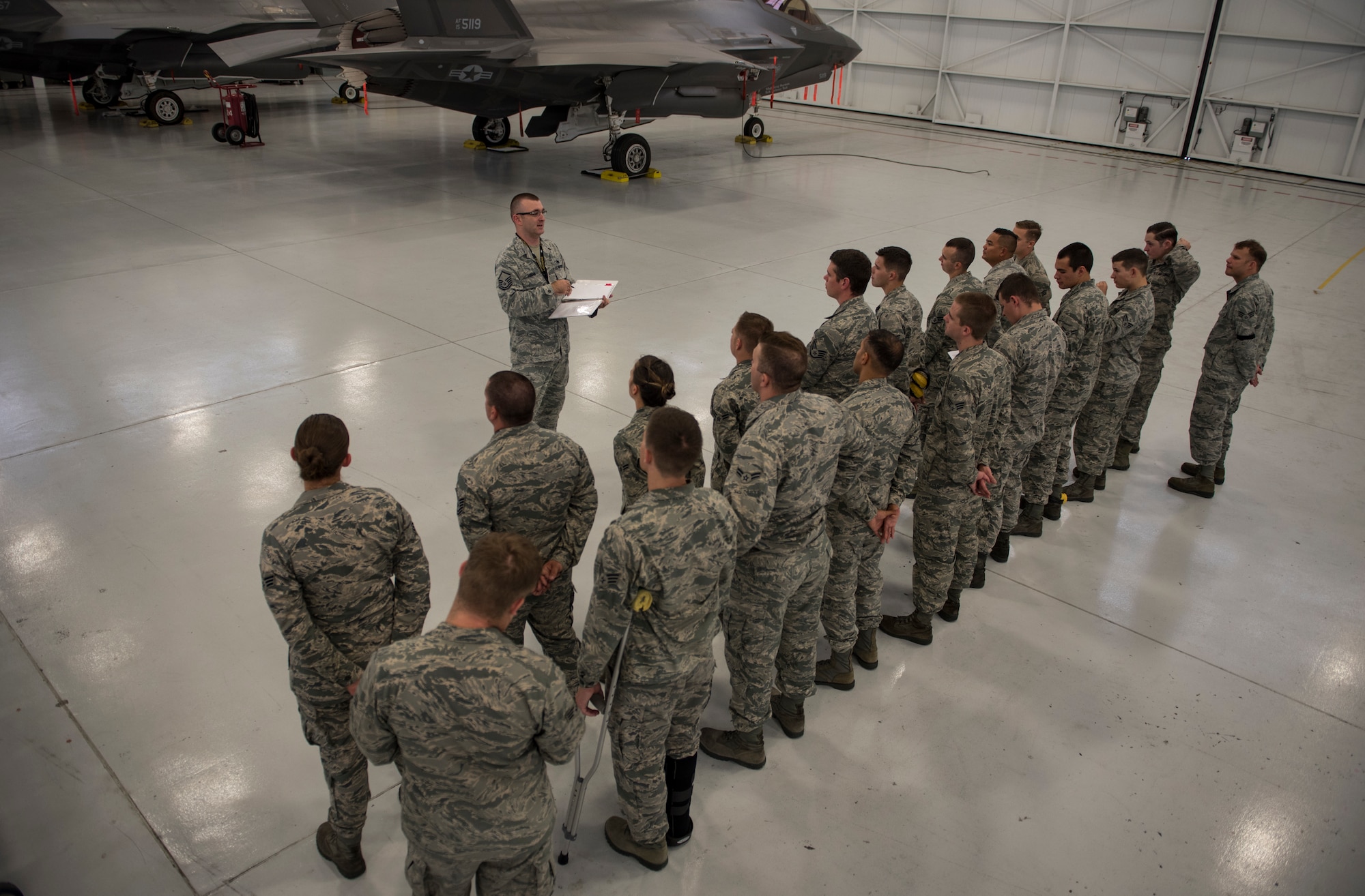Airmen assigned to the 57th Aircraft Maintenance Squadron Lightning Aircraft Maintenance Unit line up in formation for roll call at Nellis Air Force Base, Nevada, July 24, 2018. Airmen must attend roll call to get the task list for their shift. (U.S. Air Force photo by Airman 1st Class Andrew D. Sarver)