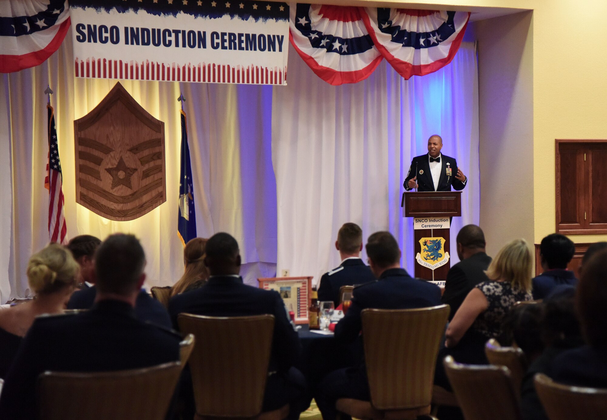 U.S. Air Force Chief Master Sgt. Keith Castille, Headquarters Air Education and Training Command operations superintendent for the profession of arms center of excellence, Joint Base San Antonio-Randolph, Texas, delivers remarks during the Senior NCO Induction Ceremony at the Bay Breeze Event Center at Keesler Air Force Base, Mississippi, Aug. 17, 2018. More than 50 inductees were recognized during the event. (U.S. Air Force photo by Kemberly Groue)