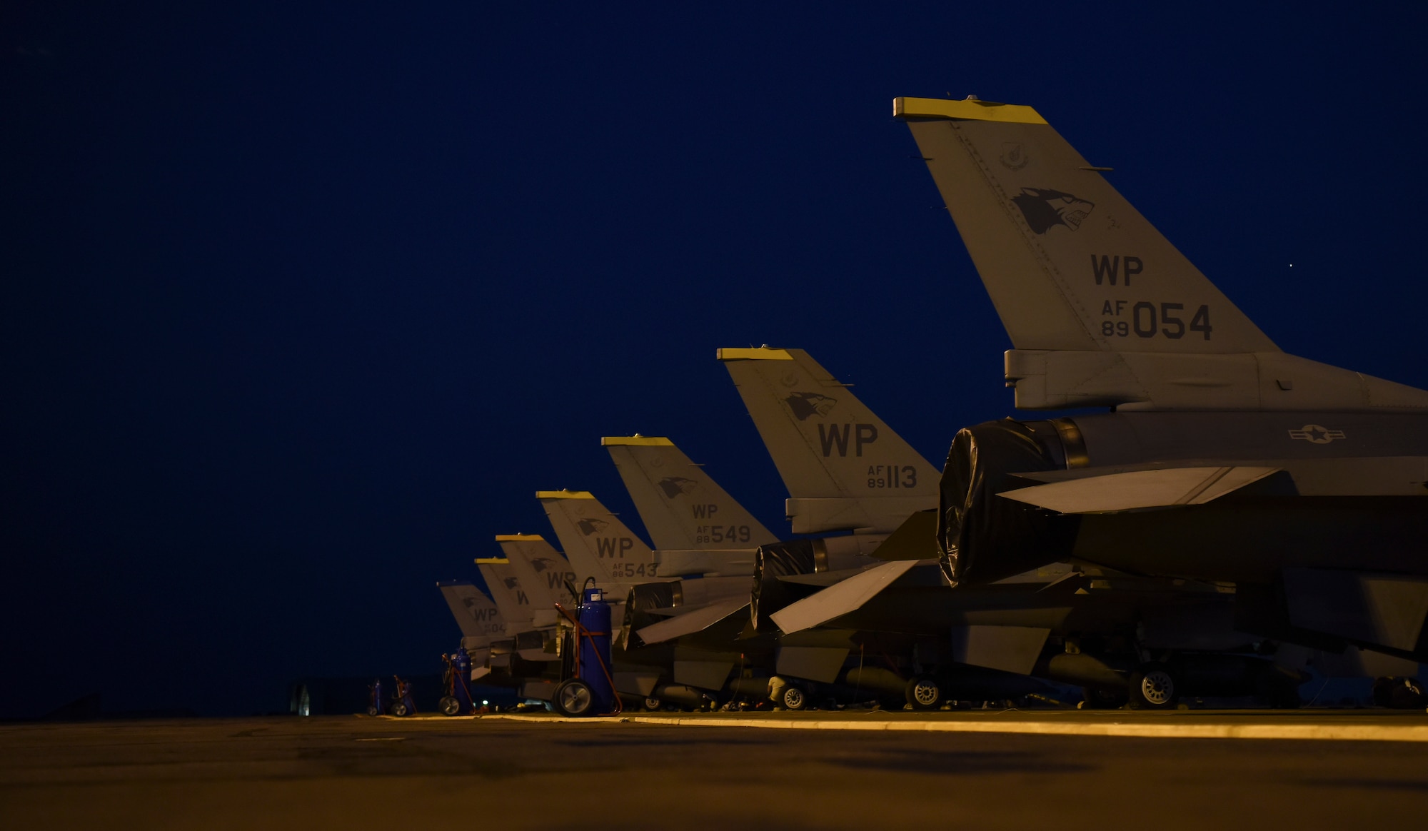 A row of U.S. Air Force F-16 Fighting Falcons, assigned to Kunsan Air Base, Republic of Korea, are parked for regular maintenance checks during Exercise Pitch Black 2018 at Royal Australian Air Force Base Darwin, Australia, July 31, 2018. This exercise allows regional partners and participating nations to exercise deployed units in the tasking, planning, and execution of offensive counter-air and offensive air support while utilizing one of the largest training airspace areas in the world. (U.S. Air Force photo by Senior Airman Savannah L. Waters)