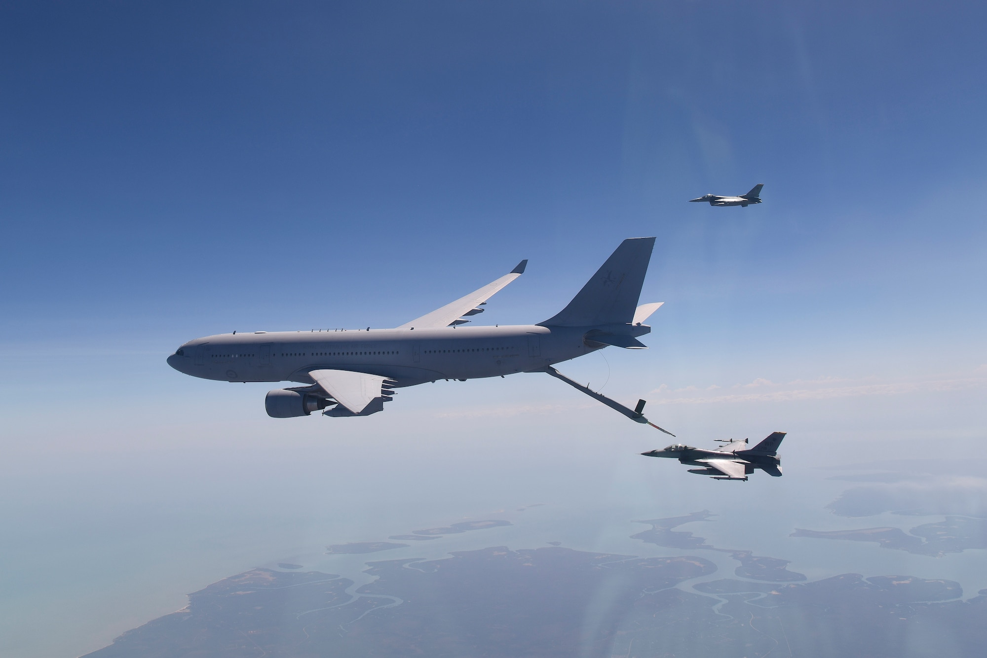 A pair of U.S. Air Force F-16 Fighting Falcons, assigned to Kunsan Air Base, Republic of Korea, fly over the Northern Territory, Australia, while receiving air-to-air refueling from a Royal Australian Air Force KC-30A Multi-Role Tanker Transport aircraft during Exercise Pitch Black 2018, Aug. 7, 2018. This training focuses on exercising international forces in the planning and execution of large-scale offensive, counter-air and counter-land operations in a coalition environment against a capable adversary force. (U.S. Air Force photo by Senior Airman Savannah L. Waters)